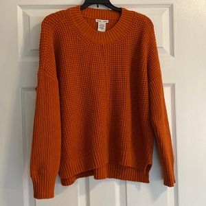 Orange knit sweater with midline seam. Size large.